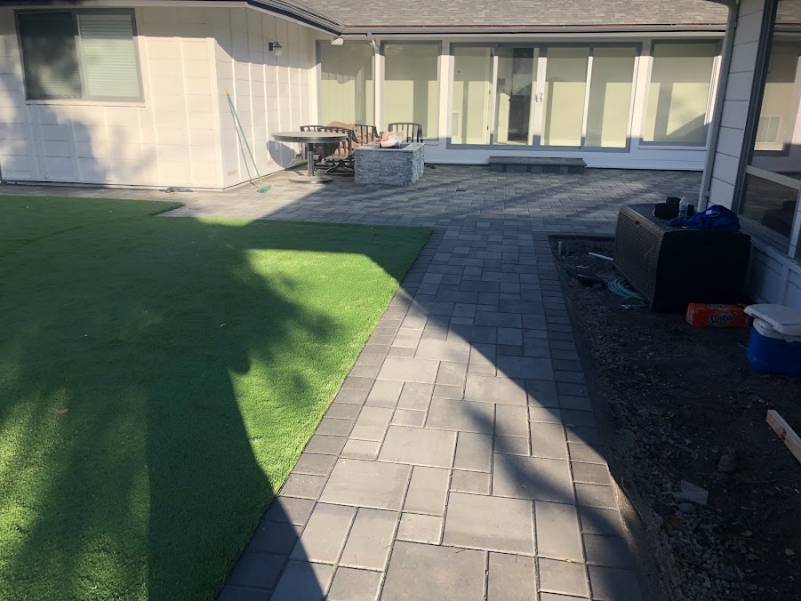 Backyard with artificial turf and a paver patio