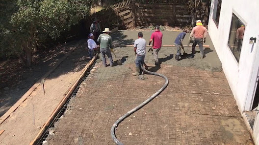 Crew pouring and finishing concrete on-site
